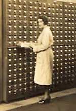 Woman searching card catalogue at Mundanaeum.