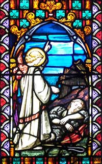 Stained glass window showing Saint Patrick visited by an angel while in slavery.
